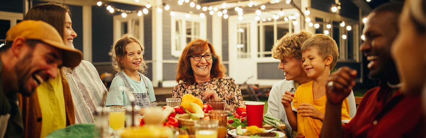 A group of family and friends enjoy dinner in the backyard
