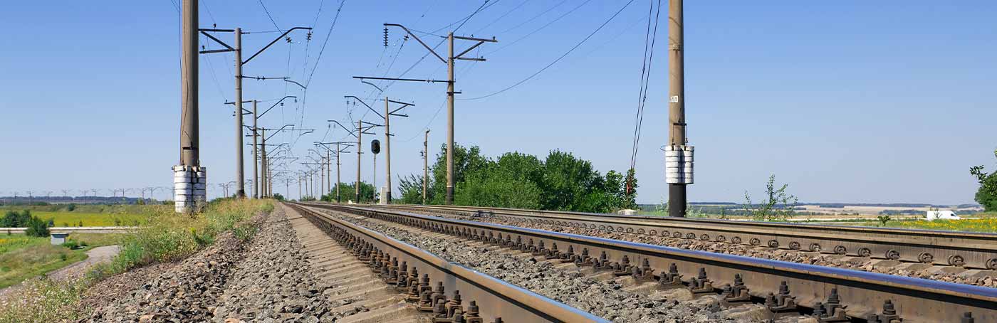 An image of phone poles following alongside railroad tracks